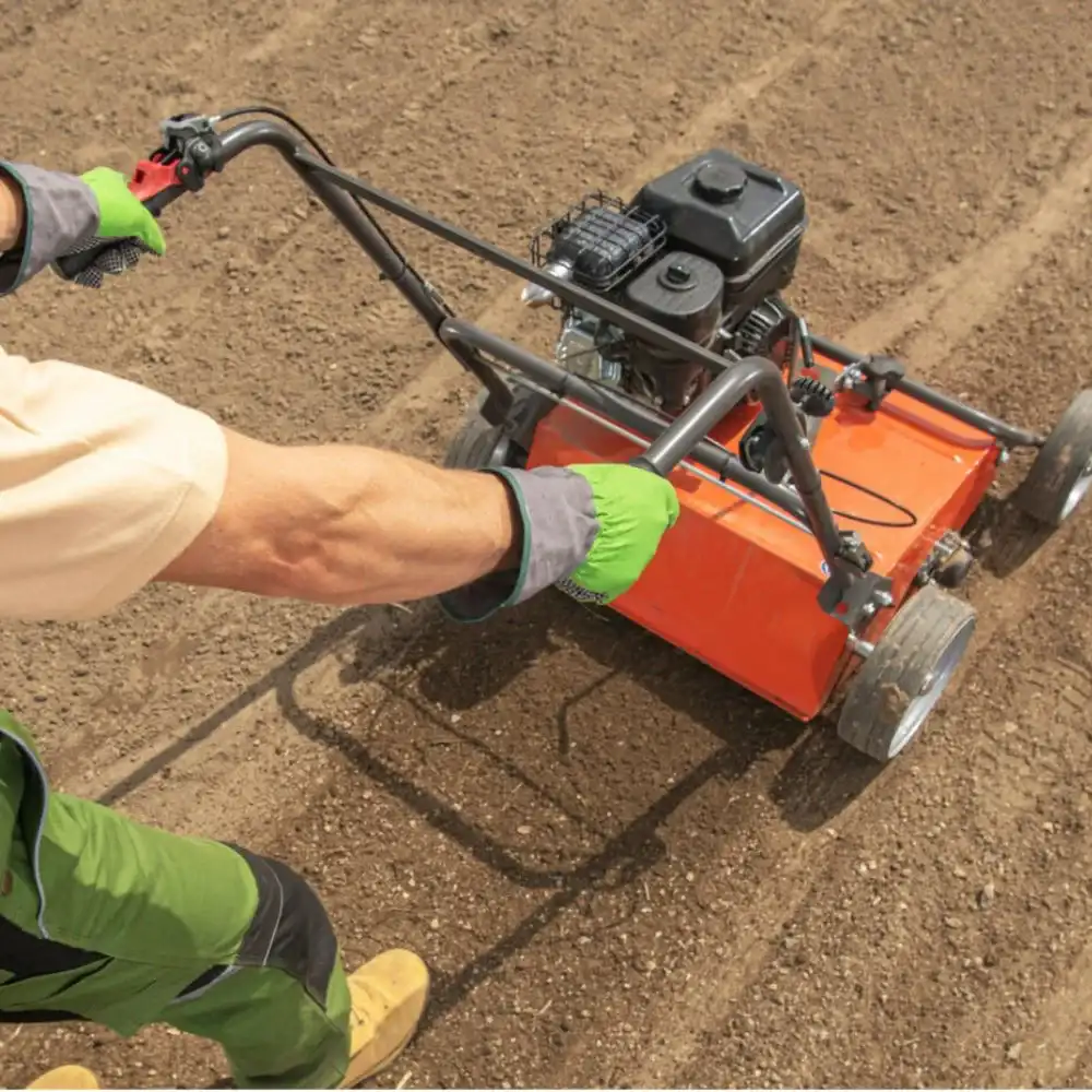 commercial operator using a professional gas-powered walk-behind lawn scarifier and dethatcher for better landscaping in clarence ny