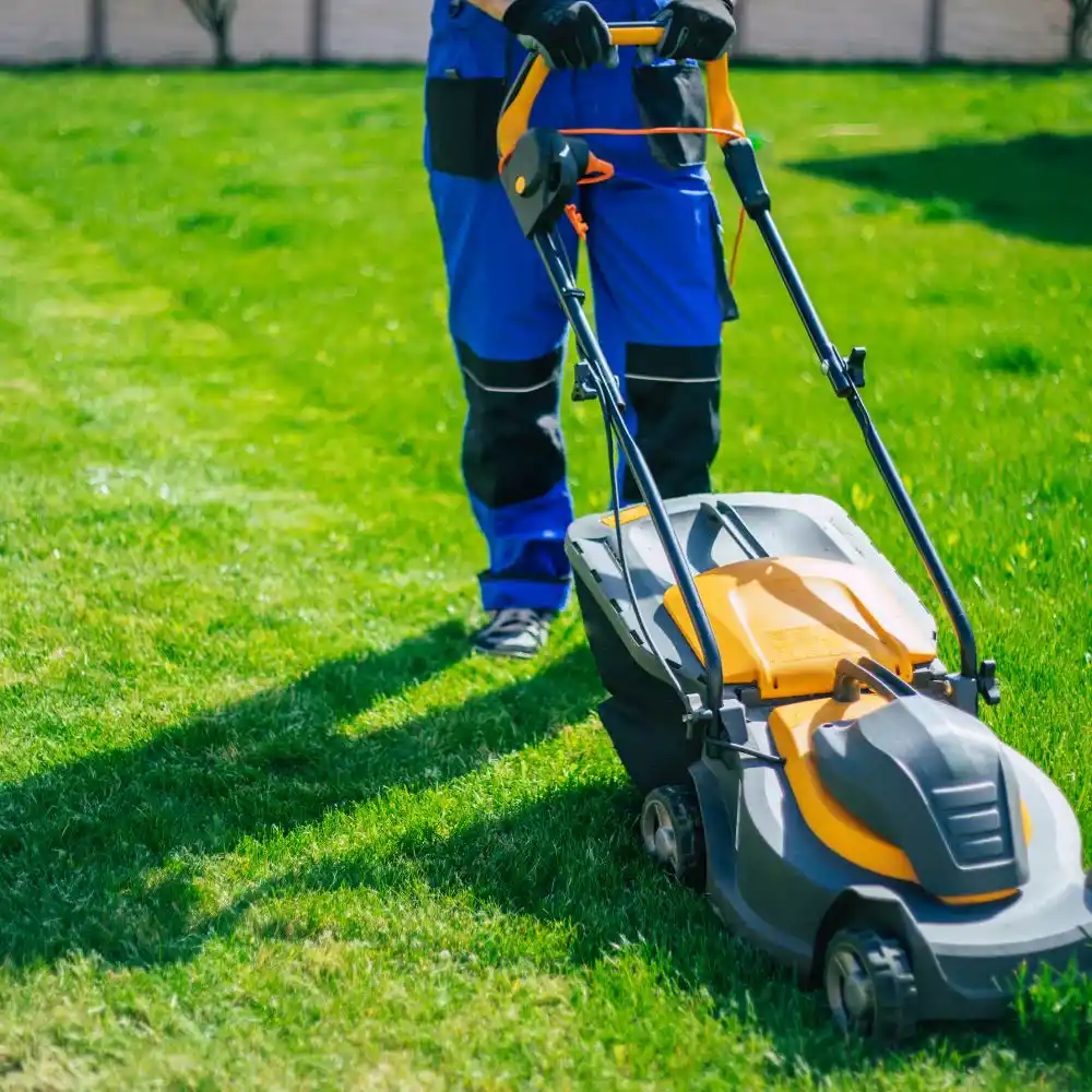 operator pushing a lightweight walk-behind electric rotary lawn mower for professional landscaping in east amherst ny