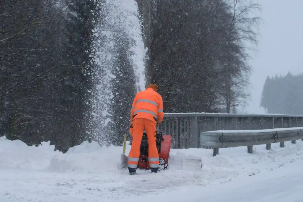 commercial worker operating a heavy-duty two-stage walk-behind gas snow blower for snow removal in clarence ny
